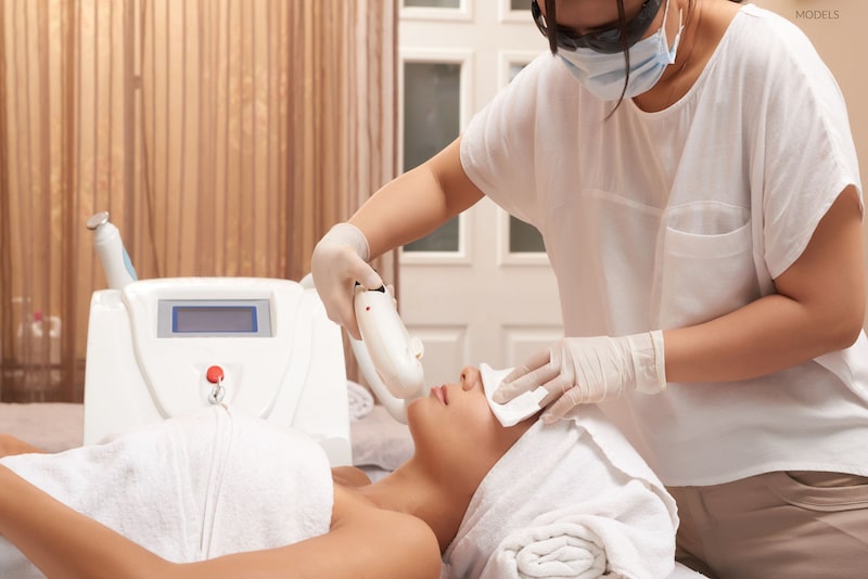 Asian woman undergoing a laser treatment on her face.